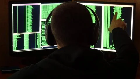 Hacker is looked to binary code. Criminal hacker penetrating network system Stockfoto's