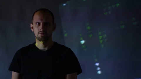 Hacker looking in camera with binary codes from monitor Stock Footage 107382079
