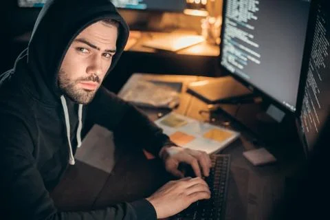 Hacker looking at camera coding on computer organizing cyber attack 스톡 사진