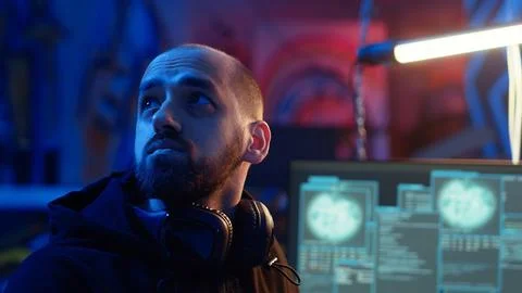 Hacker looking over shoulder and feeling anxious after stealing data Stock Photos