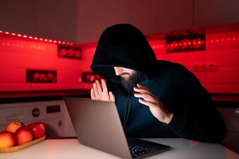 Hacker a man with a beard at a laptop Stock-Fotos