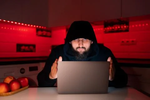 Hacker a man with a beard at a laptop Stock-Fotos