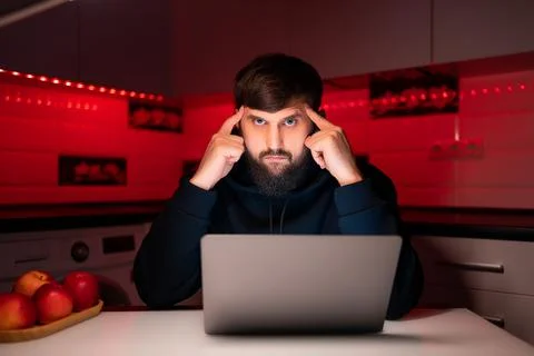 Hacker a man with a beard at a laptop Stock-Fotos