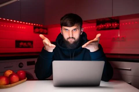 Hacker a man with a beard at a laptop Stock Photos