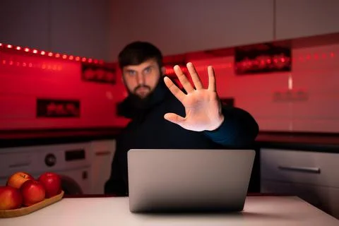 Hacker a man with a beard at a laptop Stock Photos