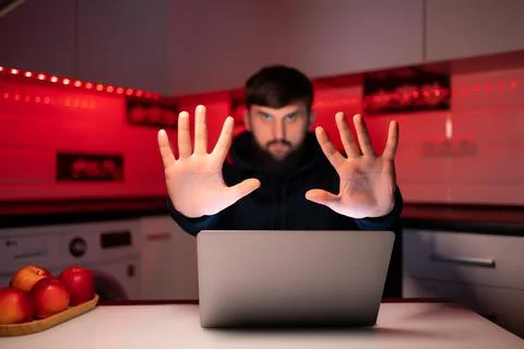 Hacker a man with a beard at a laptop Stock Photos
