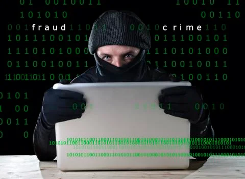 Hacker man in black using computer laptop for criminal activity hacking 写真素材