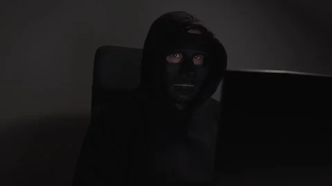 Hacker, man in mask with laptop, hacking into a network, committing cybercr.. Stock Footage 277129931