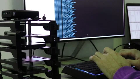 A hacker man writes the blue code for an attack. Program a virus with your co Stock Footage 144051142