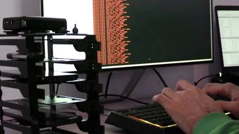 A hacker man writes the orange code for an attack. Program a virus with your  Stock Footage 144050967