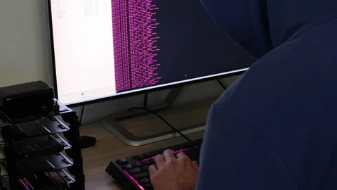 A hacker man writes the pink code for an attack. Program a virus with your co Stock Footage 144050156