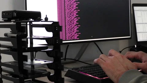 A hacker man writes the pink code for an attack. Program a virus with your co Stock Footage 144050846