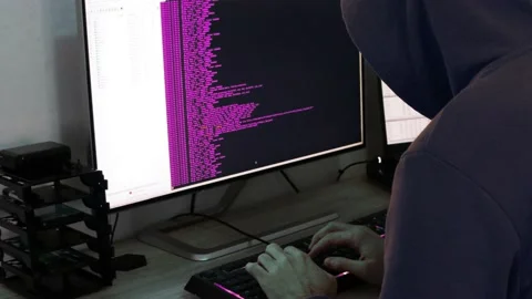 A hacker man writes the purple code for an attack. Program a virus with your  Stock Footage 143873102