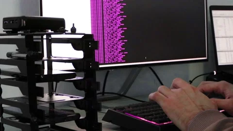 A hacker man writes the purple code for an attack. Program a virus with your  Stock Footage 144050726