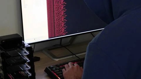 A hacker man writes the red code for an attack. Program a virus with your com Stock Footage 144050065