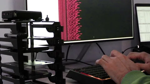 A hacker man writes the red code for an attack. Program a virus with your com Stock Footage 144050570