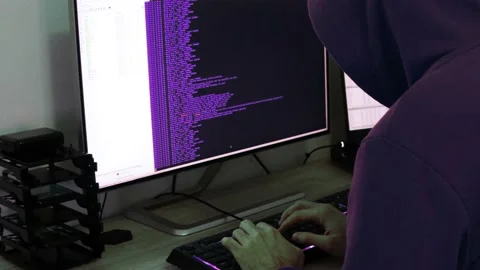 A hacker man writes the violet code for an attack. Program a virus with your  Stock Footage 143878657
