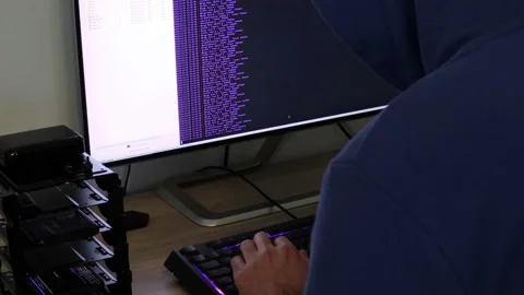 A hacker man writes the violet code for an attack. Program a virus with your  Stock Footage 144049998