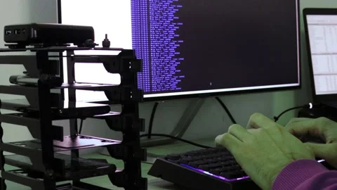 A hacker man writes the violet code for an attack. Program a virus with your  Stock Footage 144050461
