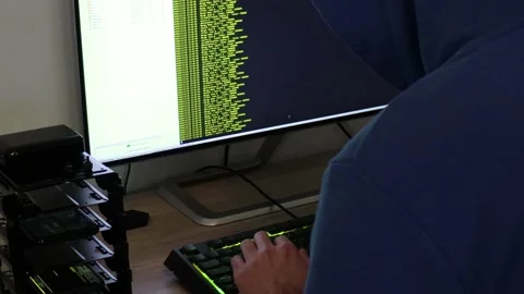 A hacker man writes the yellow code for an attack. Program a virus with your  Stock Footage 144049939