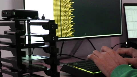 A hacker man writes the yellow code for an attack. Program a virus with your  Stock Footage 144050391