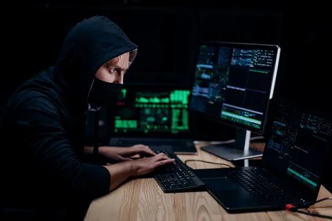 Hacker in mask coding on computer 스톡 사진