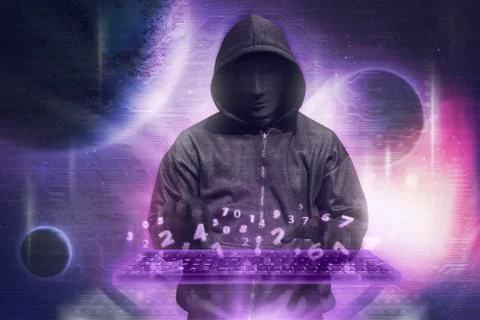 Hacker in mask typing keyboard hacking binary data Stockfoto's