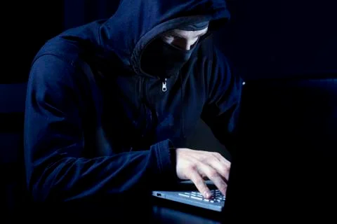 Hacker with mask using laptop computer Foto stock