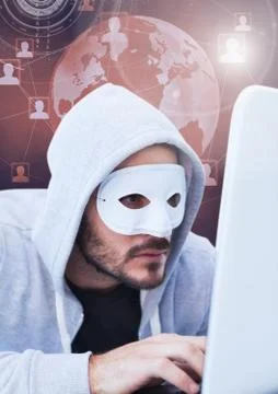 Hacker with a mask using a laptop in front of 3d digital background Stock Photos