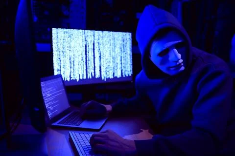 Hacker in mask working with computers in dark room. Cyber attack 스톡 사진