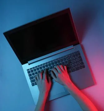 Hacker. Online worker. Night work at the laptop. Female hands are typing over 库存照片