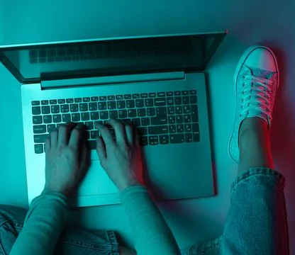 Hacker. Online worker. Night work at the laptop. Female hands are typing over 스톡 사진