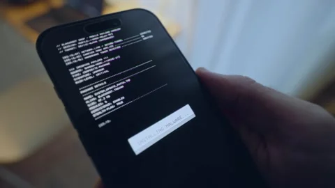 Hacker or spy holding smartphone as malware or virus is install on device Vidéo 343260020
