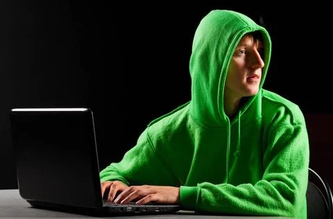 Hacker portrait hacker. Young man with laptop is looking back ,model relea... Stock-Fotos