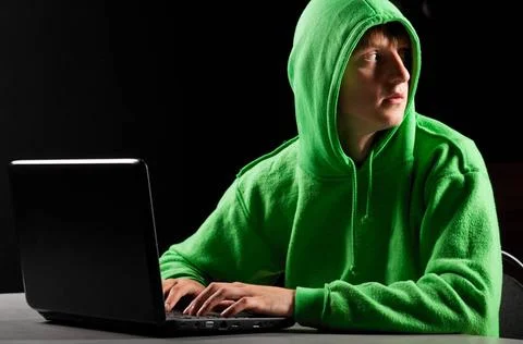 Hacker portrait hacker. Young man with laptop is looking back ,model relea... Stock-Fotos