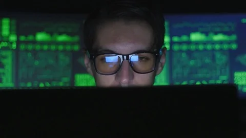 Hacker programmer in glasses is working on computer and drinking coffee in cyber Stock Footage 80279789