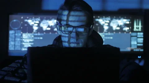 Hacker programmer in glasses is working on computer while blue code characters Stock Footage 86871106
