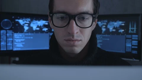 Hacker programmer in glasses is working on computer while blue code characters Stock Footage 100679671