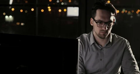 Hacker programmer man is working in the office late at night overtime. Vídeo Stock 105301501