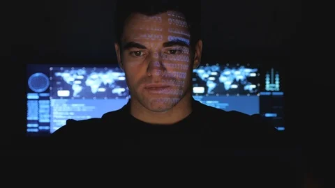 Hacker programmer working on computer in a data center while blue code Stock Footage 102927022