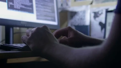 Hacker programming against the map and analysis on the wall Stock Footage 72476896