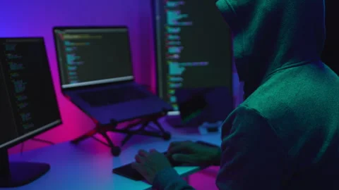Hacker Programming on Dual Monitors Displaying Code in a Tech Workspace 動画素材 336678421