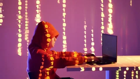 Hacker in red hoodie coding in dark room with binary code projection on wall Stock Footage 307011484
