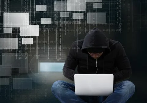 Hacker seated with cross-legged using a laptop in front of digital background Stock Photos
