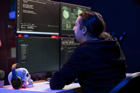 Hacker in secret hideout coding malware designed to exploit network backdoors Stock Photos