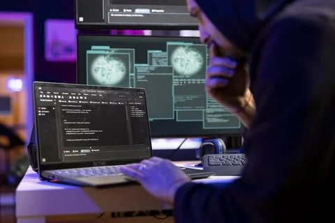 Hacker in secret lair coding on laptop to break into secure computer systems 写真素材