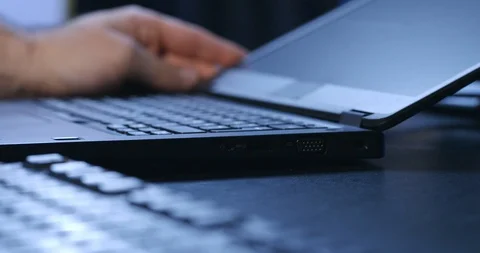 Hacker - Shady man inserts a USB device to laptop Stock Footage 98339361