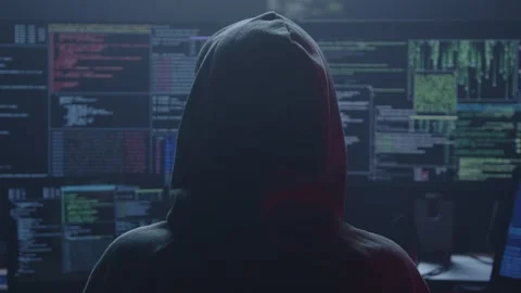 A hacker sits in a dim room surrounded by screens showing complex data Stock Footage 281759756