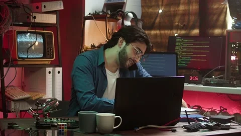 Hacker speaking on smartphone, looking at microchip. Young Spanish man Stock-Footage 164490273