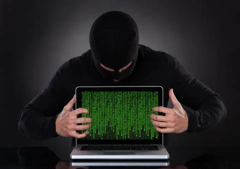 Hacker stealing data of a laptop computer Stock Photos